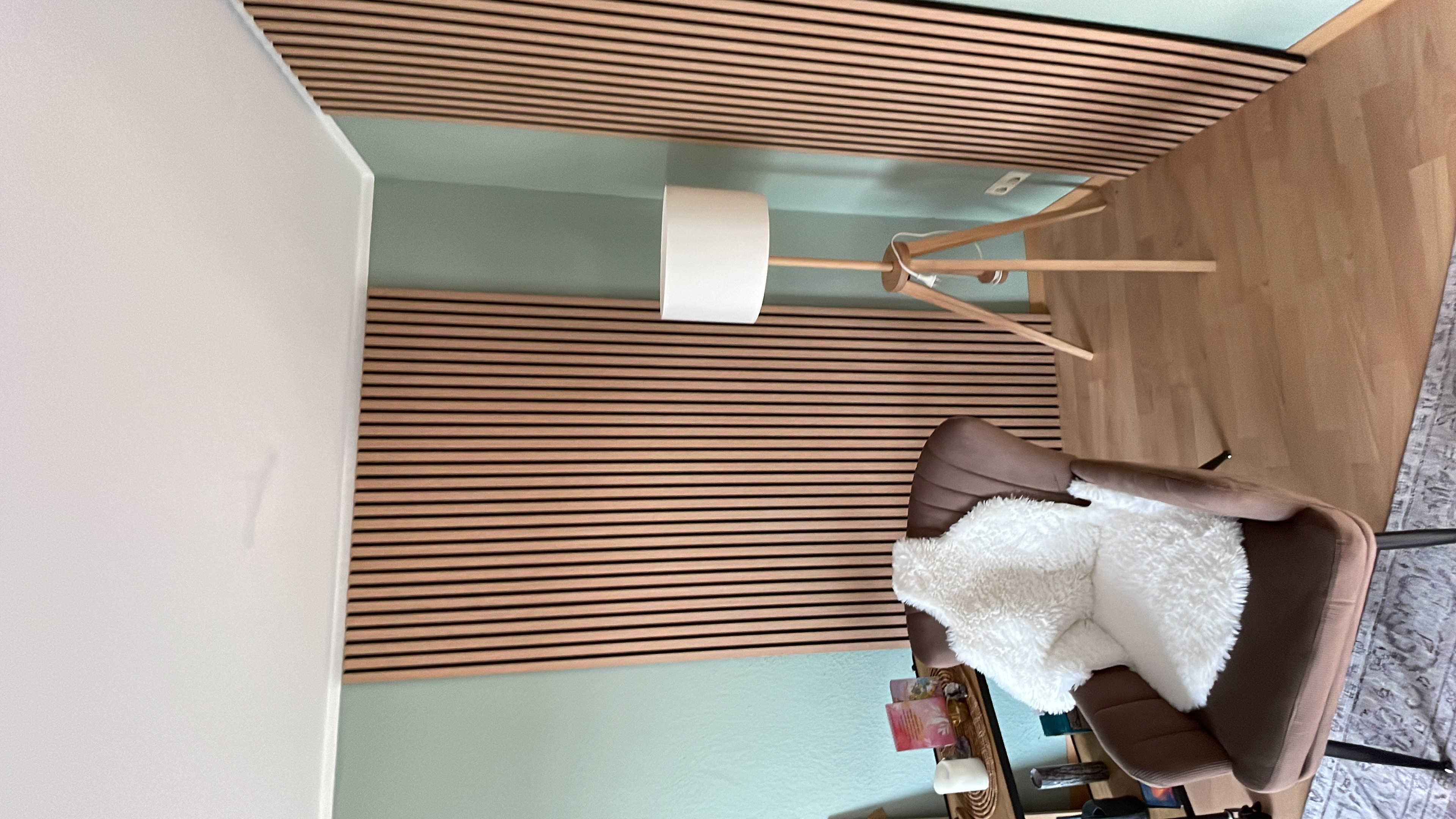 Wohnraum mit Holzpaneelen und mintgrüner Wand